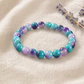 Bracelet en fluorite arc-en-ciel posé sur un lin crème